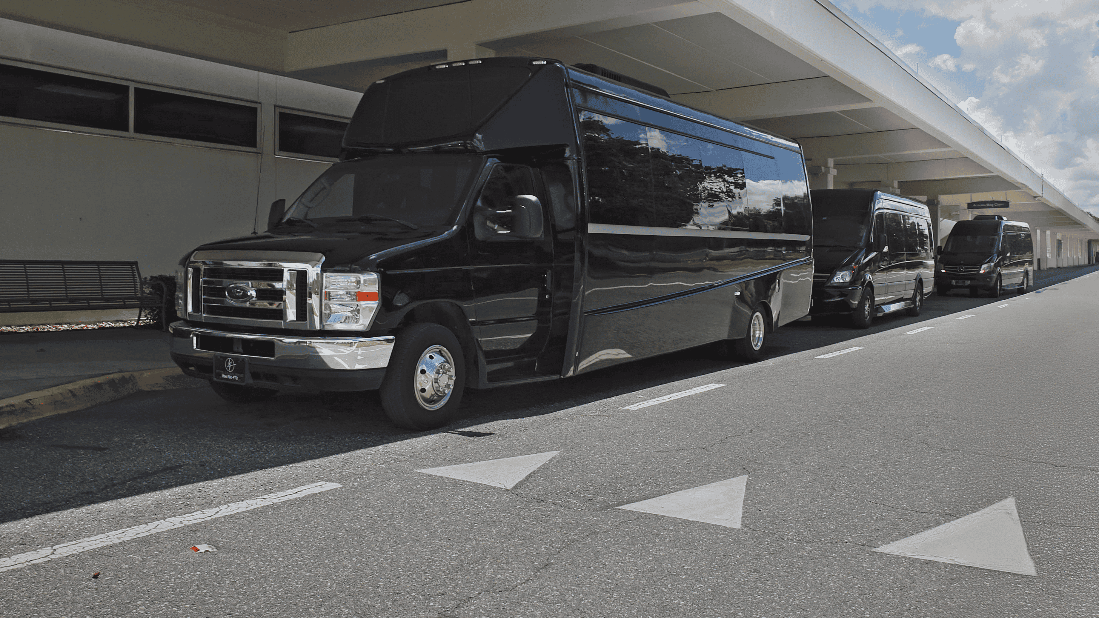Executive shuttle bus and Mercedes Sprinter vans staged at Gainesville Regional Airport for airport shuttle service and corporate group transportation.