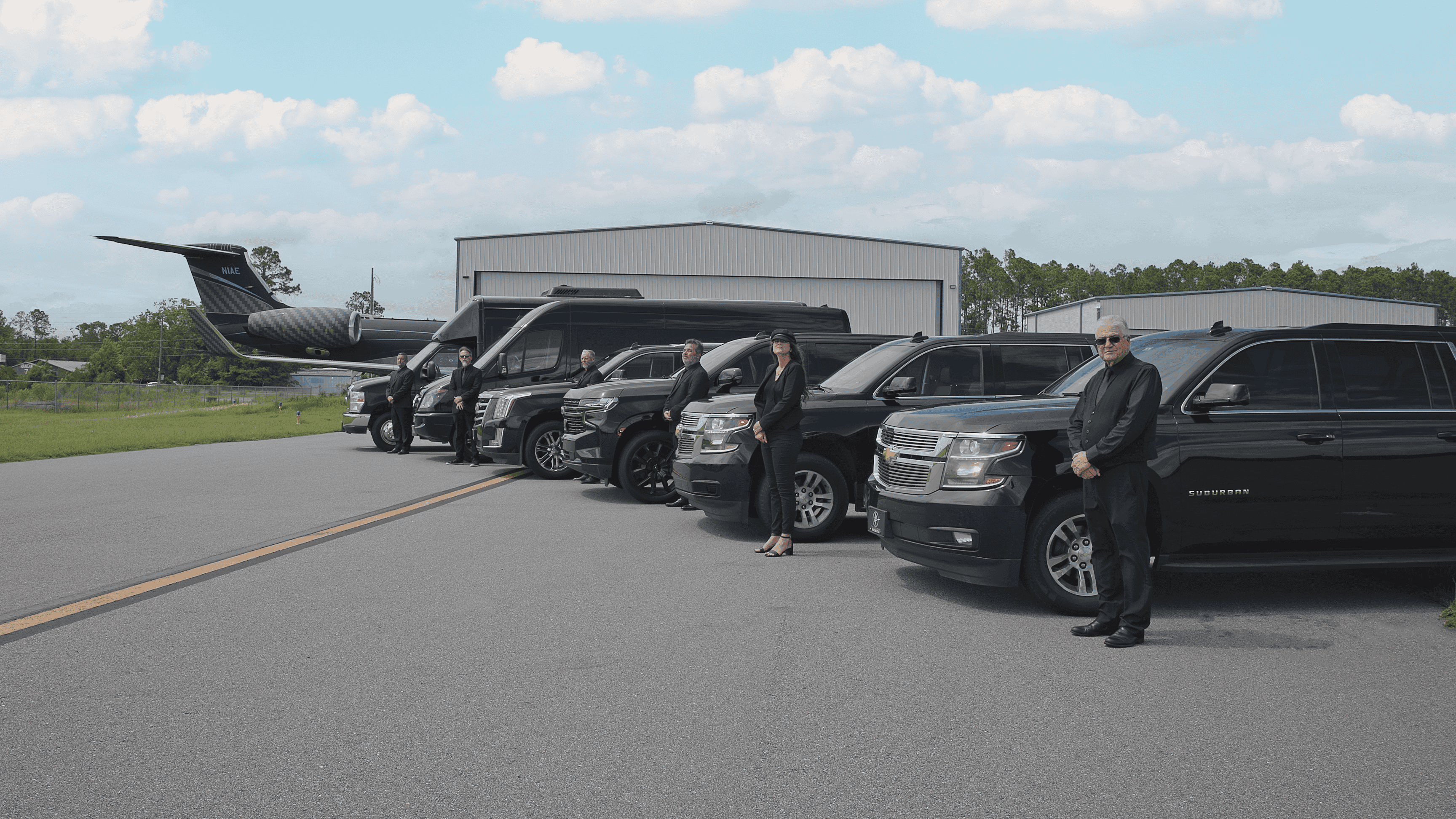 FTS Limousine chauffeurs standing beside executive SUVs, Sprinter vans, and luxury vehicles at University Air Center in Gainesville, providing private aviation transportation.