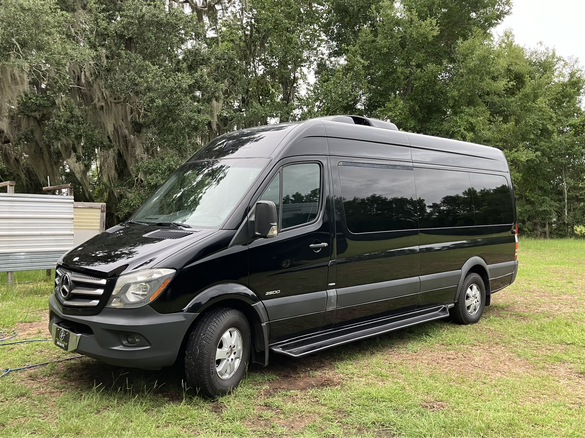 14-Passenger Mercedes Sprinter parked in grass at a wedding event venue