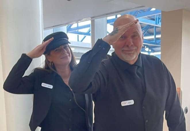 Two FTS Limousine elite chauffeurs posing and saluting their dispatch team at Jacksonville International Airport before a guest flight arrival.