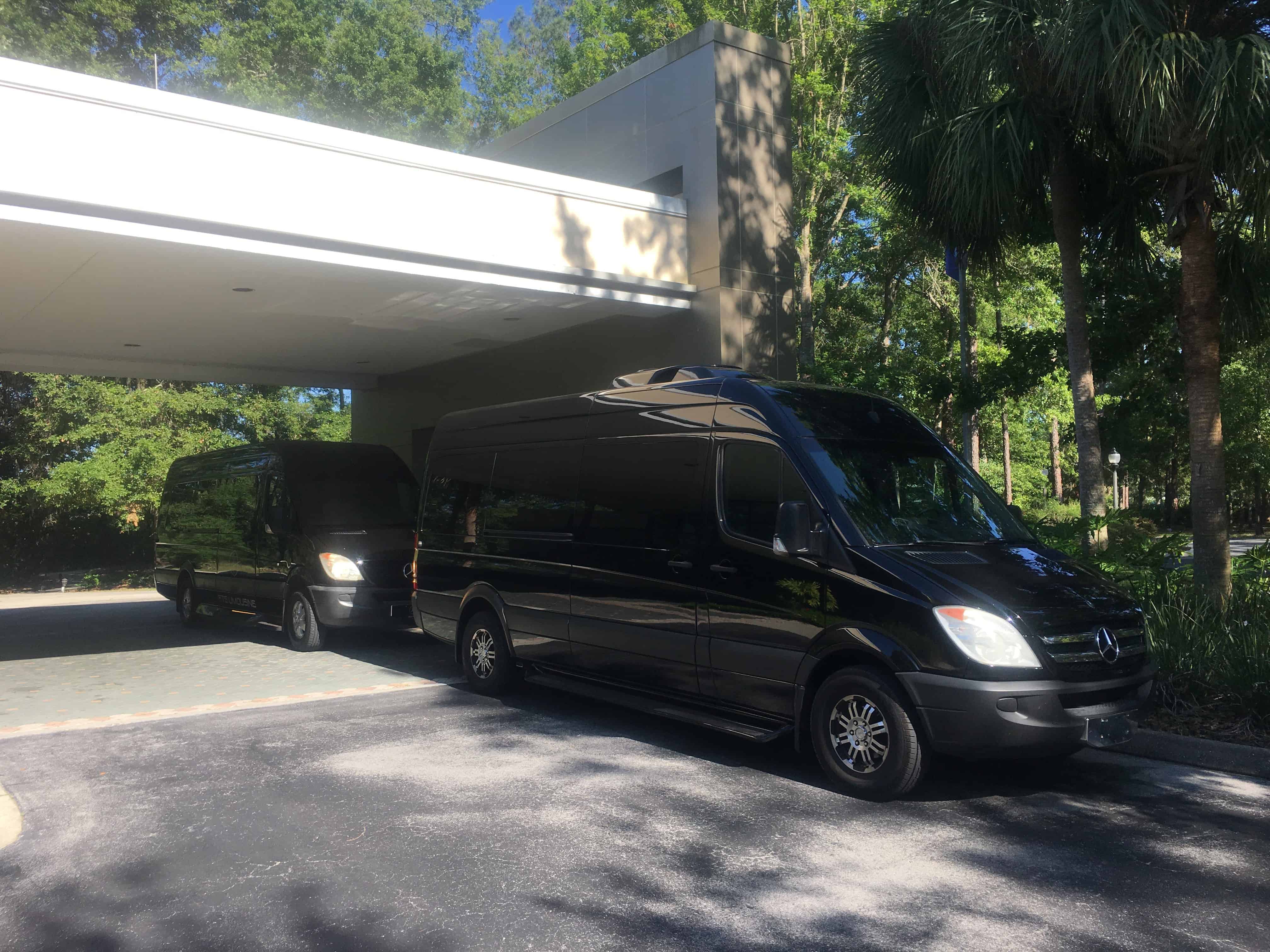 Two black Mercedes Sprinter executive vans parked at a hotel entrance in Gainesville Florida, for executive shuttle, airport transportation, and chauffeur service.
