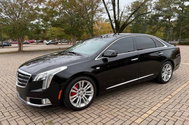 Black Cadillac XTS luxury sedan used for executive transportation.
