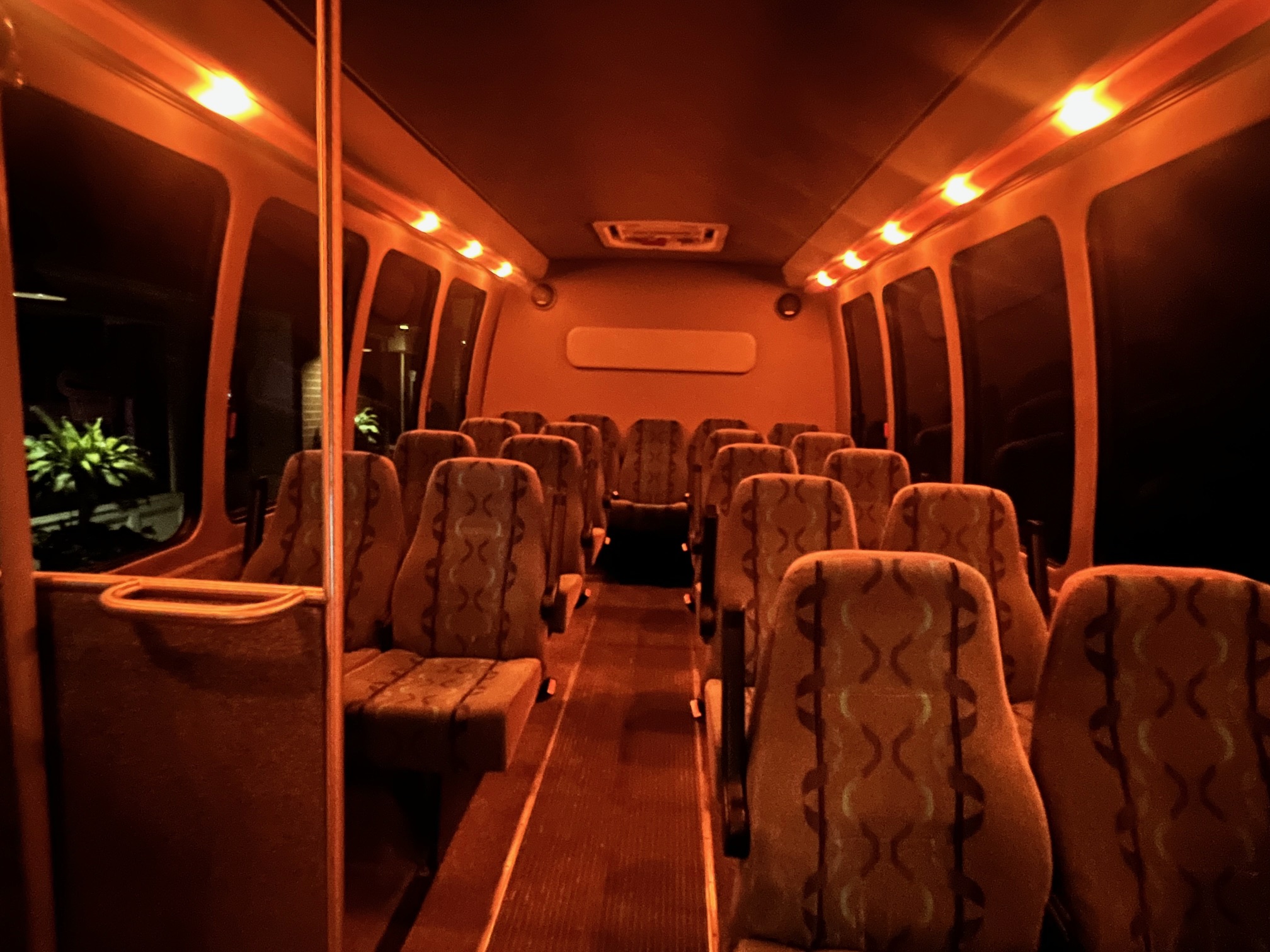 Interior of 20-passenger budget-friendly shuttle bus with comfortable seating and soft white accent lighting – Florida group transportation