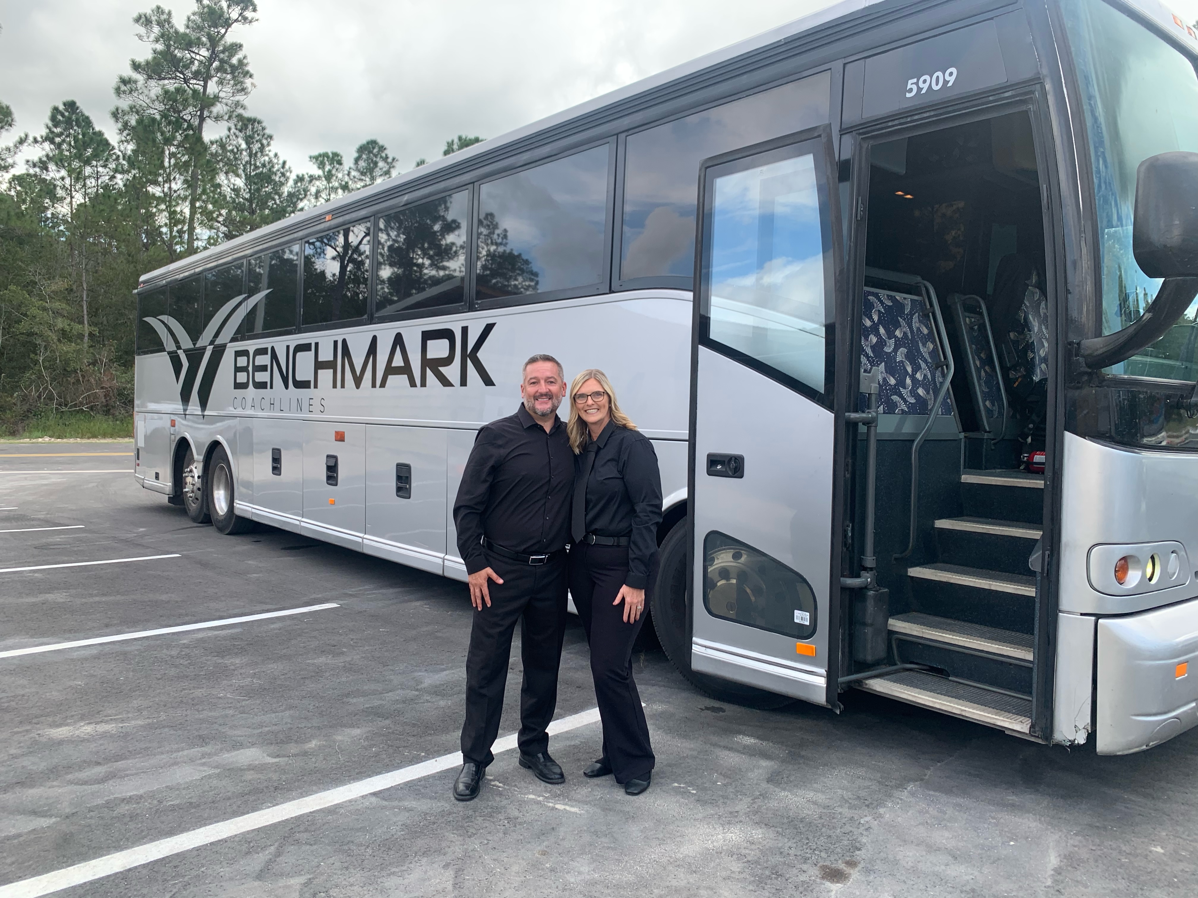 Benchmark Coachlines driver and FTS Limousine owner next to charter bus at corporate event with 2,000 guests – Florida luxury transportation