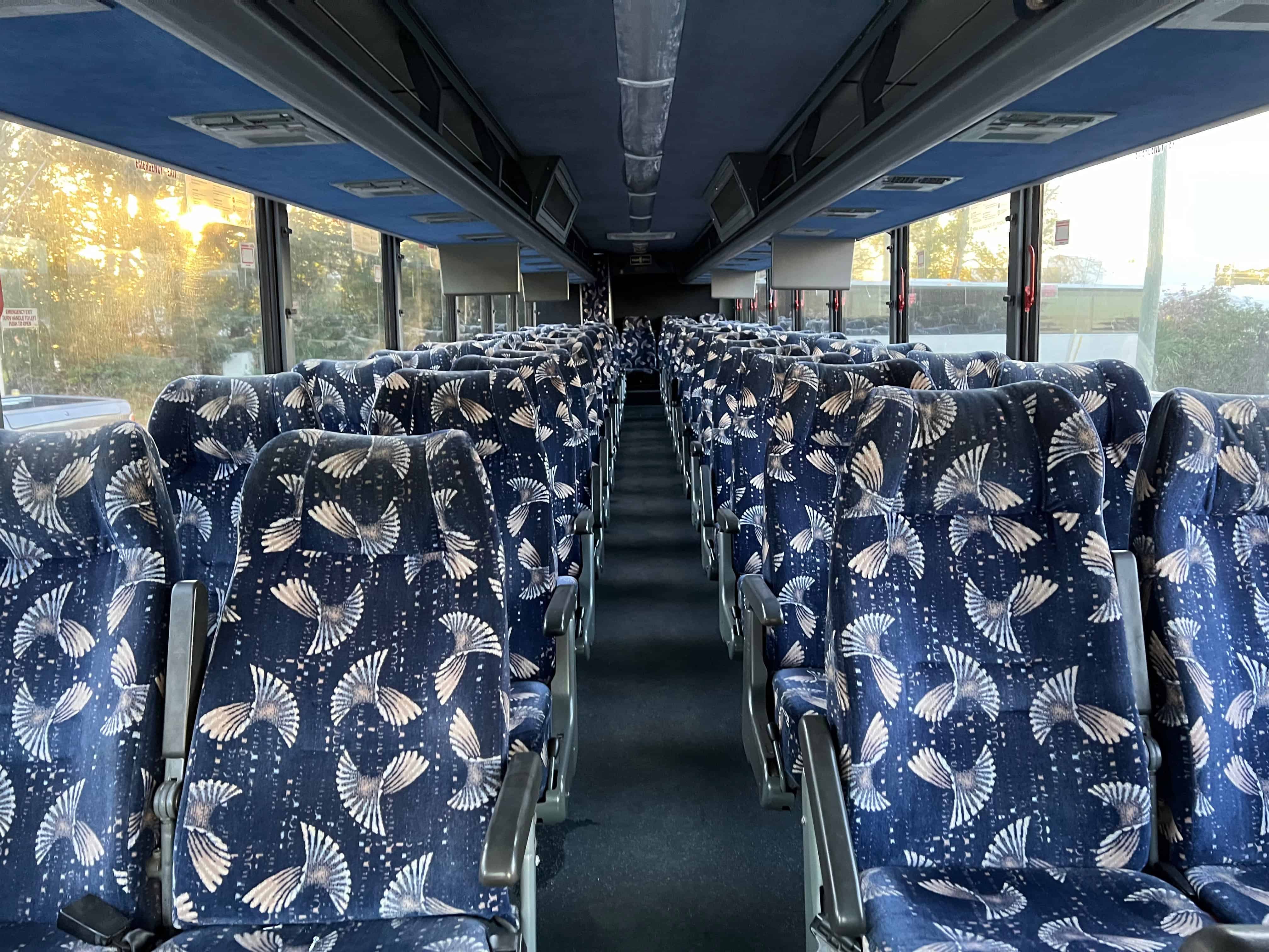 Interior of Benchmark Coachlines charter bus with plush seating, video and audio systems – FTS Limousine luxury standards in Florida