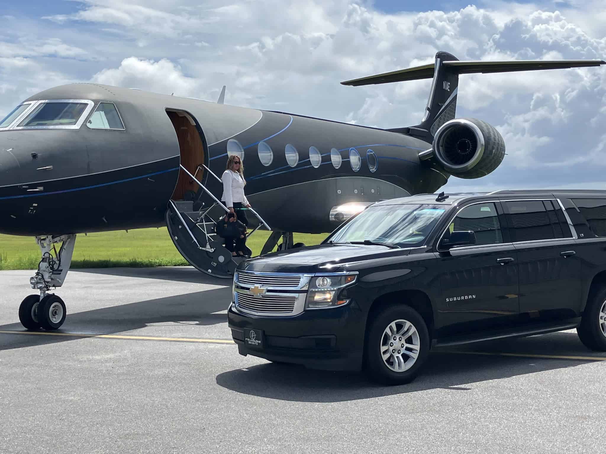 Passenger descending a private aircraft beside a luxury black SUV providing professional private airport car service and executive transportation.
