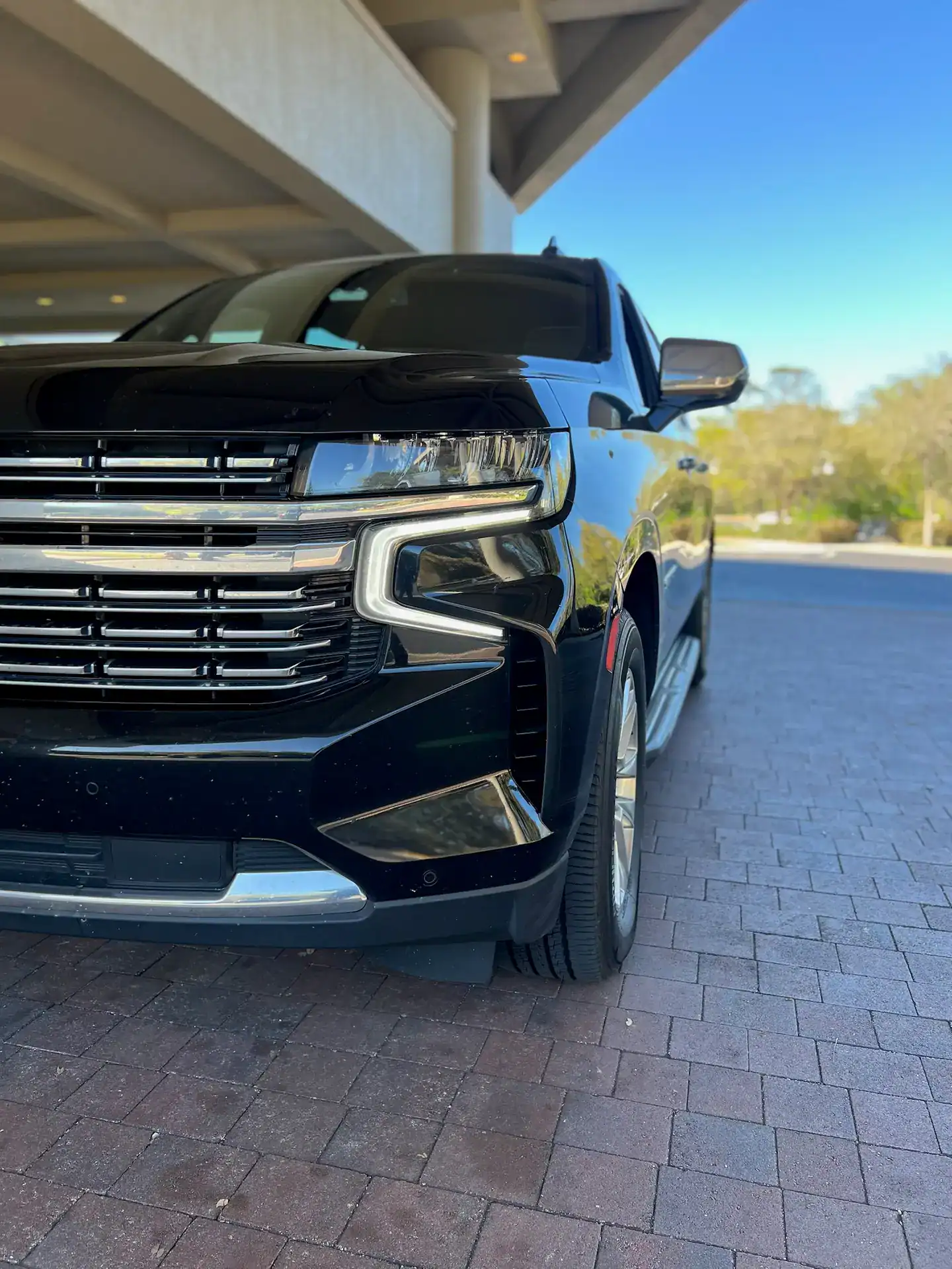 Close-up view of a luxury SUV parked outside the Sawgrass Marriott Golf Resort & Spa with the front grille and driver side prominently visible.