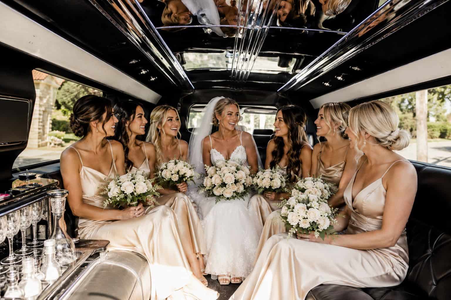 Bride and her bridesmaids traveling inside an FTS Limousine stretch limousine on the way to the wedding ceremony.