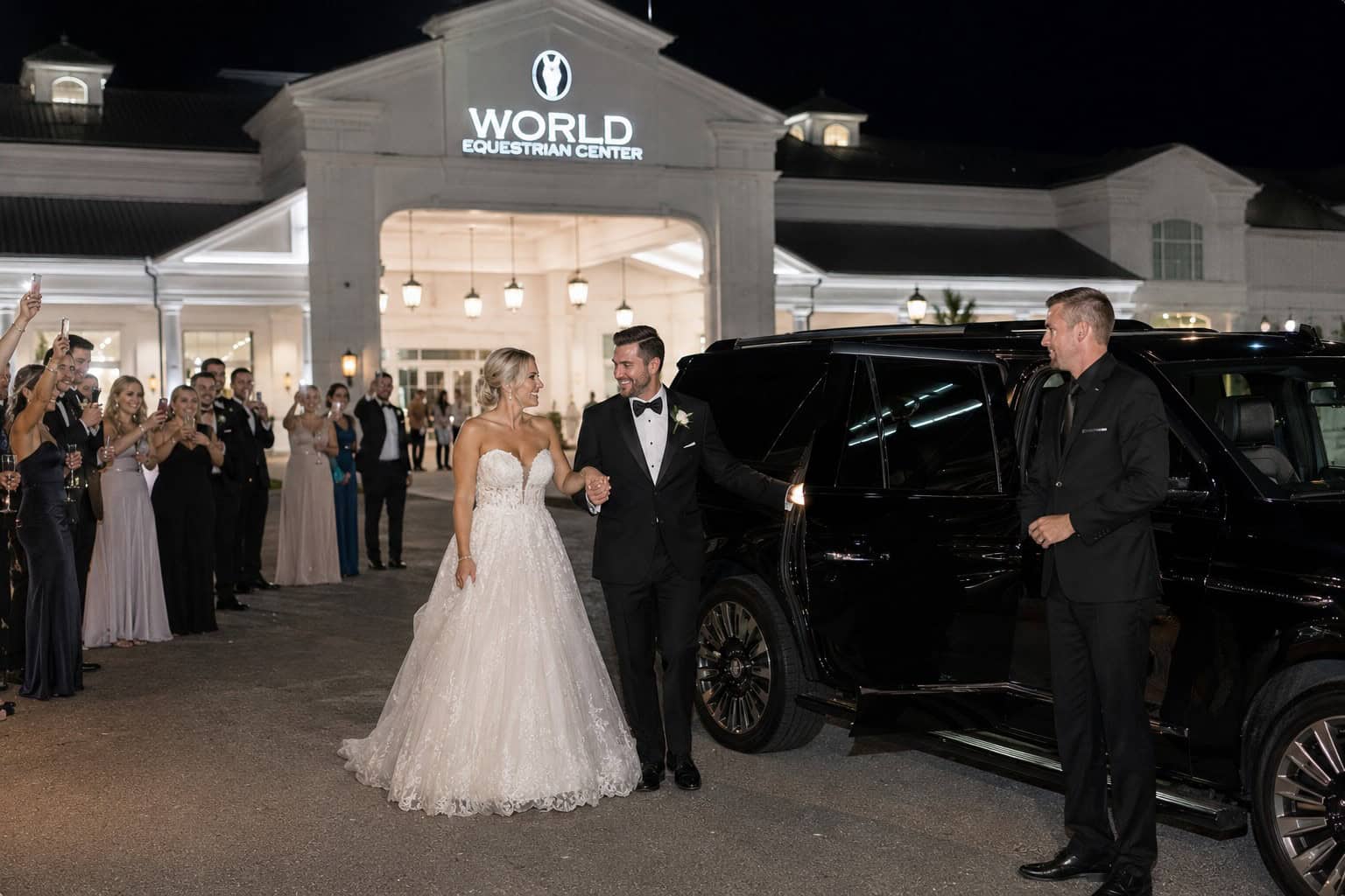 Bride and groom greeted by a professional chauffeur beside a luxury SUV at the World Equestrian Center in Ocala, Florida.