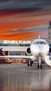 Front view of a private jet parked at Sheltair Aviation with the terminal building in the background in Ocala, Florida.